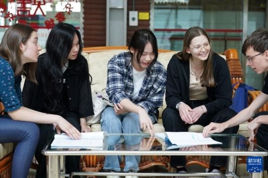 4月28日，宋智孝（右二）和胡靈月（左一）在北京首都師范大學校園內與同學交流。新華社記者 彭子洋 攝