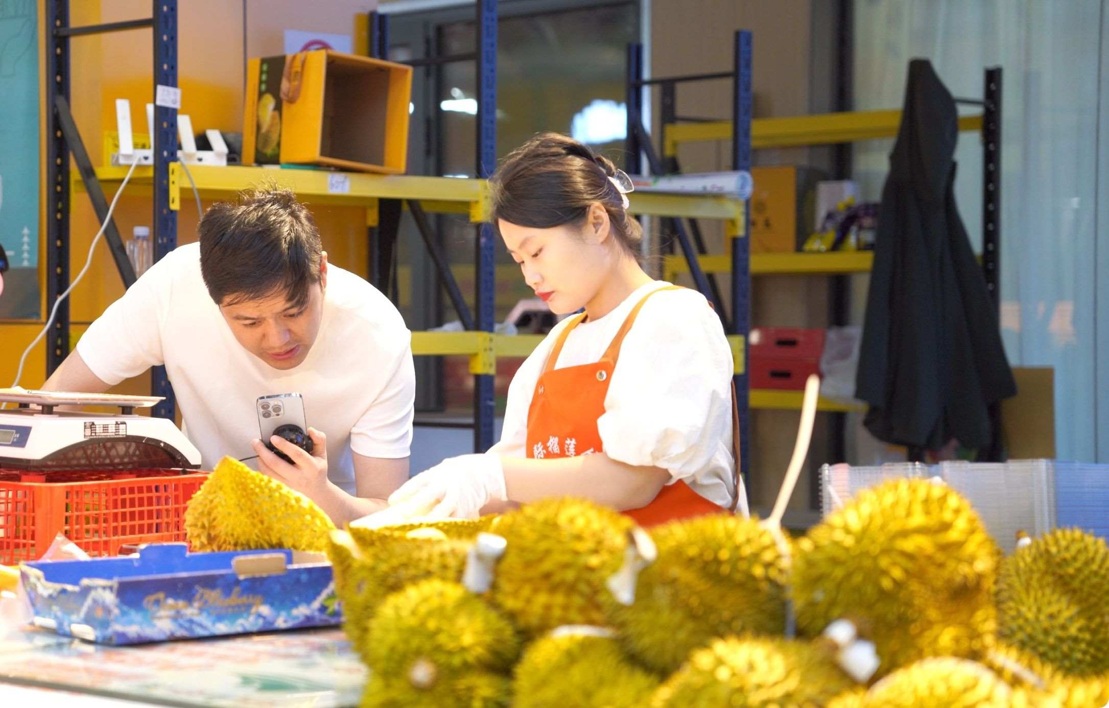 榴蓮商家正在通過(guò)手機(jī)直播銷售榴蓮。人民網(wǎng)記者申佳平 攝