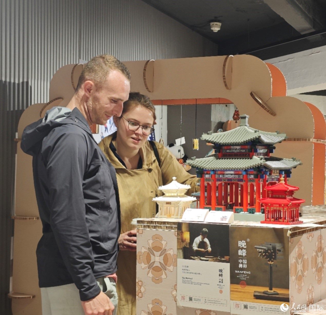 英國觀眾在欣賞中國傳統(tǒng)榫卯結構建筑模型。邢雪攝
