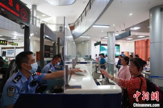 圖為旅客在磨憨口岸辦理通關(guān)手續(xù)。雷雨 攝