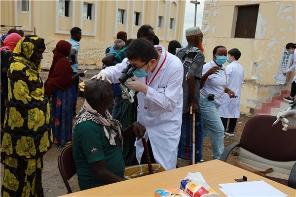 在義診現(xiàn)場(chǎng)，中國(guó)醫(yī)生與當(dāng)?shù)鼐用窈嫌傲裟?，吉布提鹽業(yè)投資公司供圖