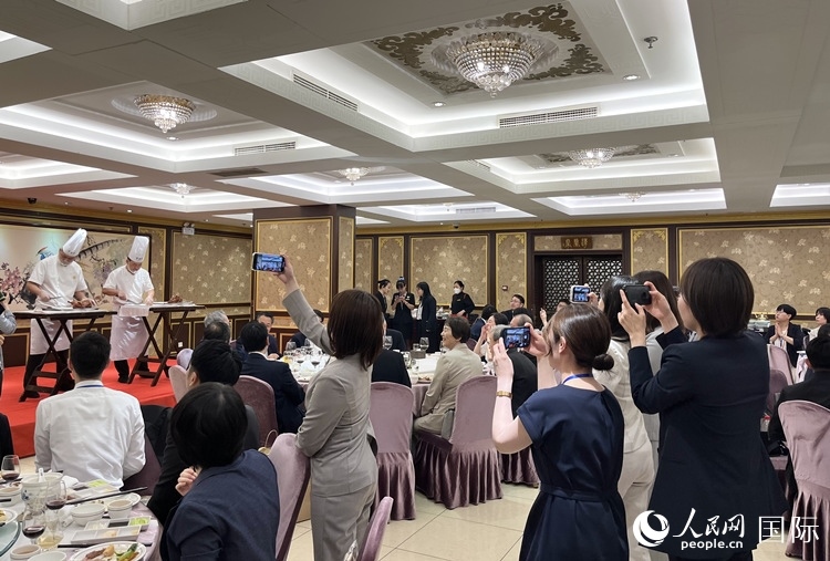 國家級非物質(zhì)文化遺產(chǎn)、全聚德片鴨工藝吸引代表團成員拍照留念。