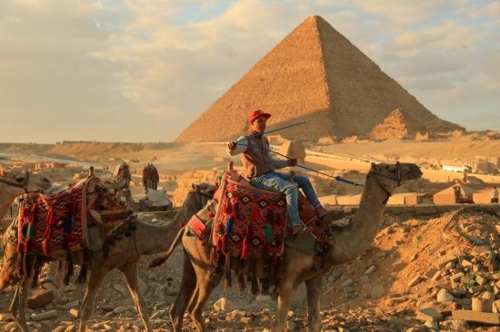 1月24日，商販騎駱駝離開埃及吉薩金字塔景區(qū)。新華社記者 隋先凱 攝