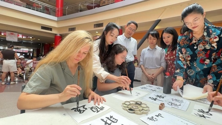 羅馬尼亞友人在活動(dòng)現(xiàn)場(chǎng)學(xué)寫漢字。中國(guó)駐羅馬尼亞大使館領(lǐng)僑處供圖