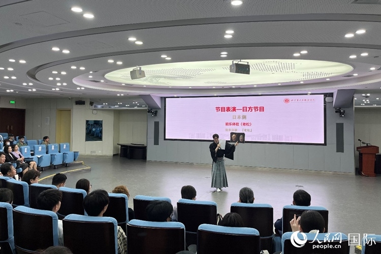 日本大學(xué)生介紹能樂知識。人民網(wǎng)記者 陳思攝