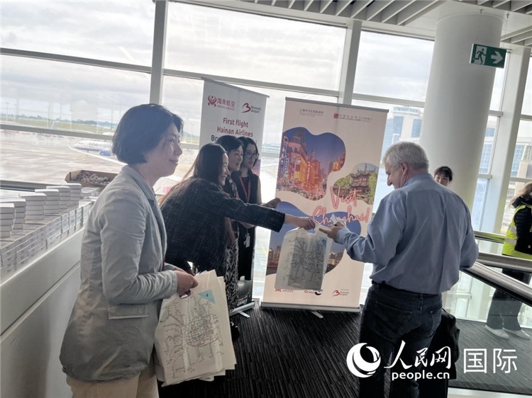 圖為工作人員向乘客發(fā)放復(fù)航首班禮物。 牛瑞飛攝