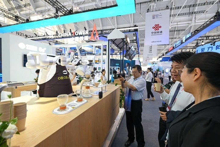 6月20日，與會者品嘗機器人沖調(diào)出的咖啡。新華社記者 孫凡越 攝