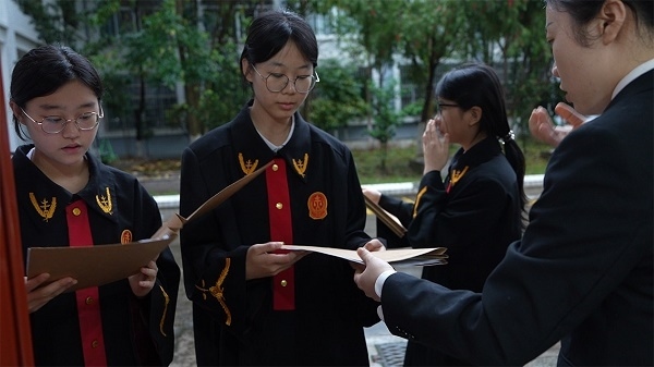 圖①：武平法院干警向?qū)W生分發(fā)道具卷宗。