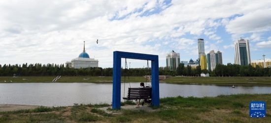 6月30日，一名女子在哈薩克斯坦首都阿斯塔納伊希姆河畔休息。新華社記者 王建華 攝