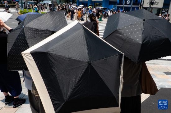 7月4日，人們?cè)谌毡緰|京原宿的街道上等待紅綠燈。新華社記者 張笑宇 攝