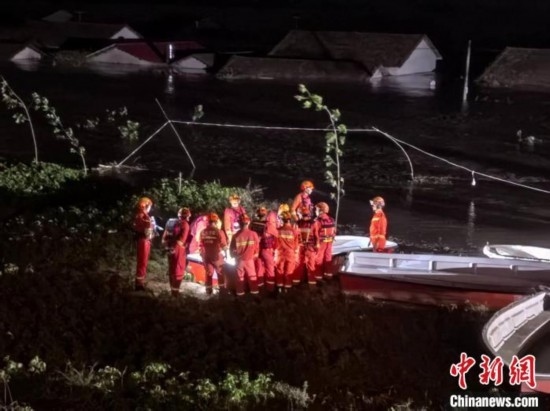  7月6日凌晨3時(shí)，在湖南岳陽華容縣團(tuán)洲垸洞庭湖一線堤防，救援人員剛剛完成一次救援任務(wù)，遠(yuǎn)處是被淹的民房。中新社記者 白祖偕 攝