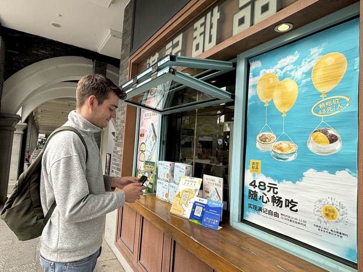 來自德國的留學生理查德在杭州西湖邊一家商鋪使用支付寶掃碼支付（2024年4月11日攝）。新華社發(fā)
