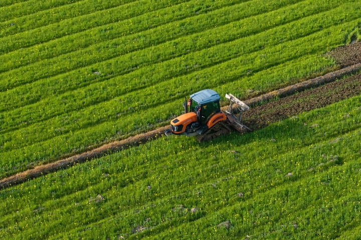 2024年3月19日，在湖南省常德市鼎城區(qū)謝家鋪鎮(zhèn)港中坪村，村民駕駛農(nóng)機(jī)翻耕田地（無(wú)人機(jī)照片）。新華社記者 陳思汗 攝