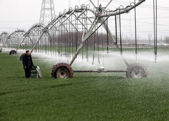 2024年3月18日，在河南省焦作市博愛縣孝敬鎮(zhèn)東原莊村瑞輝家庭農(nóng)場(chǎng)，村民使用全自動(dòng)指針式噴灌機(jī)進(jìn)行澆灌作業(yè)。新華社發(fā)（程全攝）