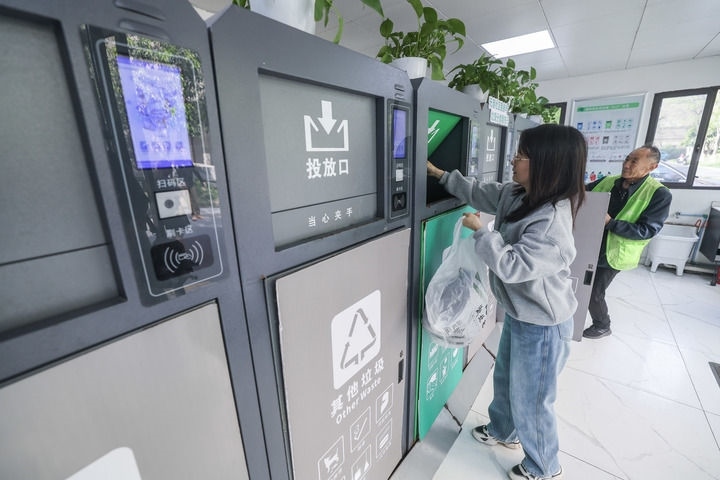 2024年4月10日，在浙江省湖州市吳興區(qū)飛英街道新華府小區(qū)內(nèi)，居民在垃圾分類智能系統(tǒng)的指導(dǎo)下進(jìn)行垃圾分類投放，居民的投放情況將實(shí)時(shí)匯總到智慧服務(wù)平臺(tái)，會(huì)有相應(yīng)的積分獎(jiǎng)勵(lì)。新華社記者 徐昱 攝