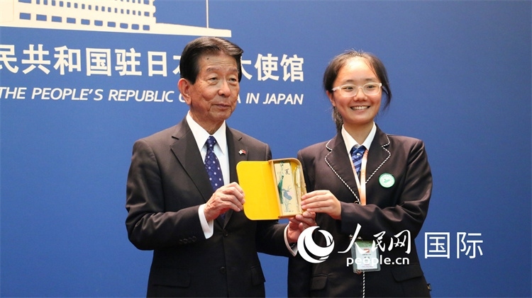 中國(guó)小大使向日本永旺1%俱樂部理事長(zhǎng)森美樹贈(zèng)送當(dāng)?shù)靥厣Y品。人民網(wǎng) 許可攝