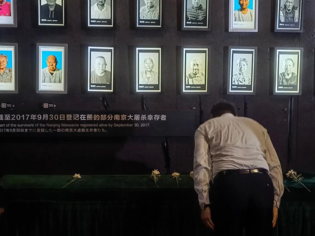 7月18日，人們向離世的南京大屠殺幸存者獻花、鞠躬。新華社記者邱冰清 攝