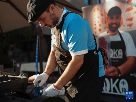 7月19日，在蕪湖古城，馬丁在當(dāng)天舉行的啤酒節(jié)上制作牛排。新華社發(fā)（繆雨晨 攝）