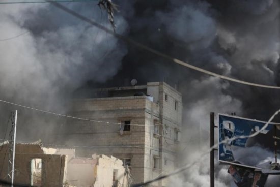 7月21日，在加沙地帶中部的努賽賴特難民營，遭以軍空襲的建筑冒出滾滾濃煙。新華社發(fā)（馬爾萬·達(dá)烏德攝）