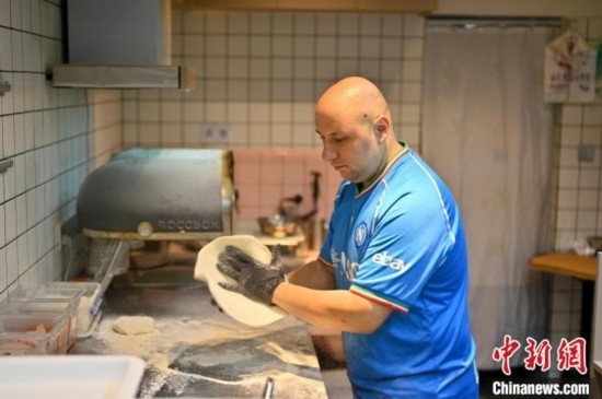 近日，韋榮耀在自家披薩小店內(nèi)忙活。俞靖 攝