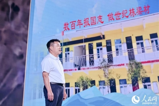 張玉滾分享用一根扁擔(dān)送孩子們走出大山的故事。人民網(wǎng)攝