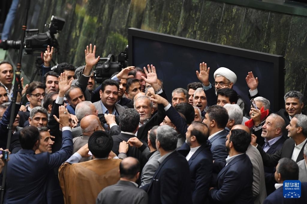 7月30日，在伊朗德黑蘭的伊朗議會(huì)，佩澤希齊揚(yáng)（中）離開總統(tǒng)就職典禮現(xiàn)場(chǎng)時(shí)揮手致意。新華社記者 沙達(dá)提 攝