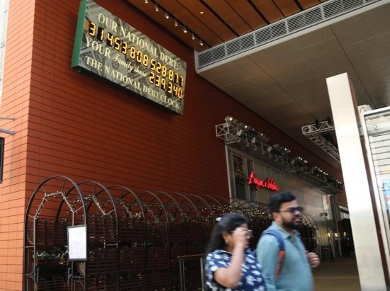 2023年5月29日，人們經(jīng)過(guò)美國(guó)紐約曼哈頓的“國(guó)債鐘”?！皣?guó)債鐘”是一個(gè)大型計(jì)數(shù)器，它實(shí)時(shí)更新美國(guó)的公共債務(wù)總額，并顯示出每個(gè)美國(guó)家庭所要負(fù)擔(dān)的數(shù)額。 新華社記者劉亞南攝