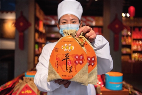 在位于山西省晉中市平遙縣的平遙古城南大街的一家平遙牛肉店內(nèi)，工作人員展示一款牛肉產(chǎn)品（資料照片）楊晨光攝 / 本刊