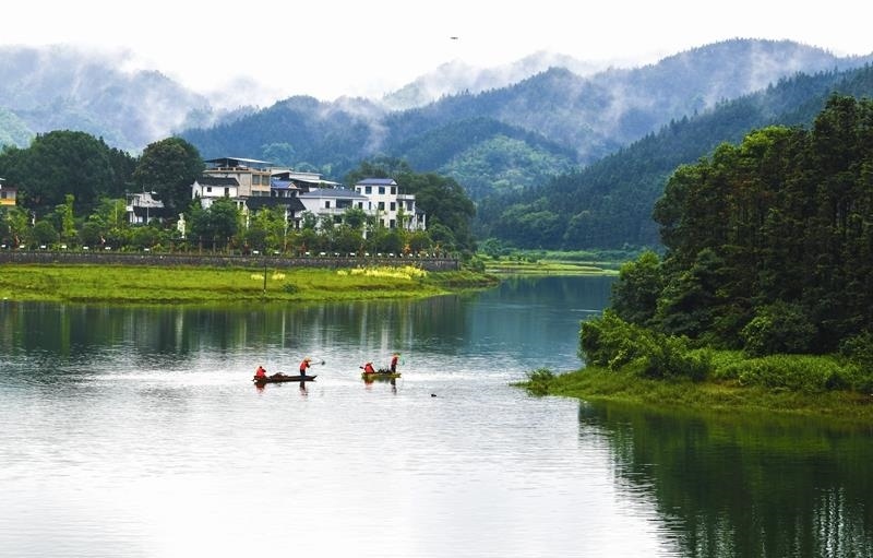 2024年6月5日，志愿者在湖南常寧市洋泉水庫清理水面漂浮物。