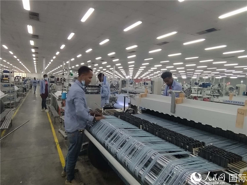 無錫金茂埃塞面料廠車間內(nèi)，當(dāng)?shù)毓と苏谝唤z不茍地作業(yè)。人民網(wǎng)記者 黃培昭攝