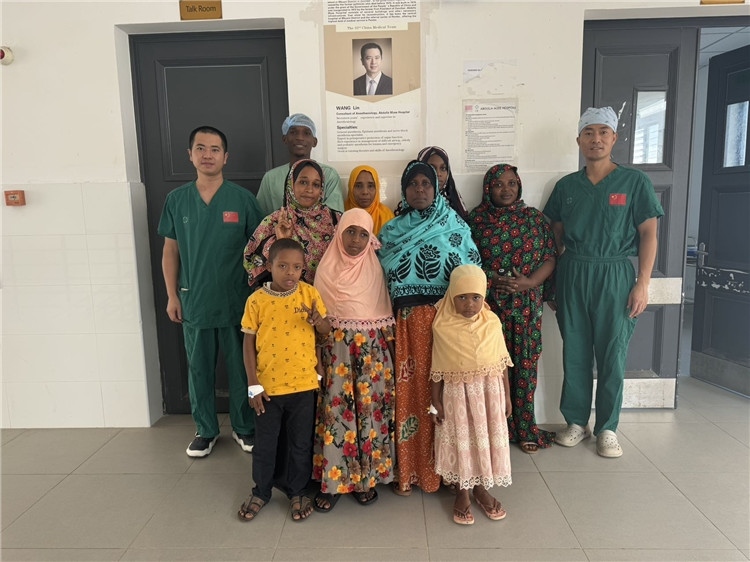 李廣（右一）和王林醫(yī)生與部分患者合影。中國援桑醫(yī)療隊供圖