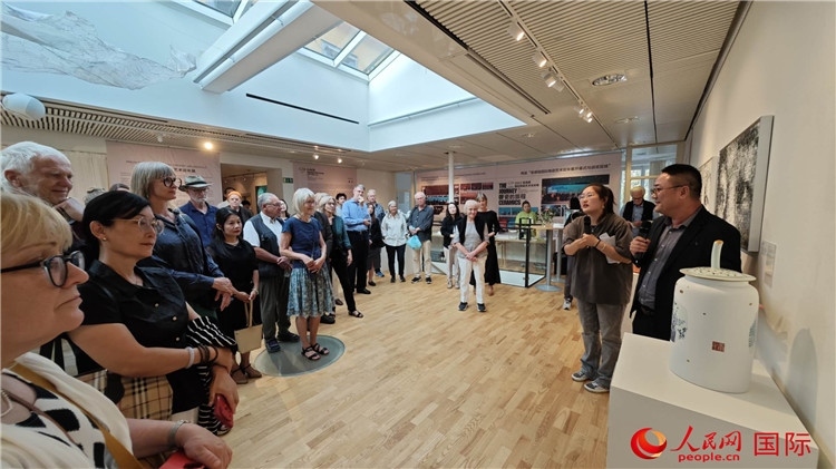 參展人、景德鎮(zhèn)陶瓷大學(xué)美術(shù)學(xué)院副院長(zhǎng)邵長(zhǎng)宗（右一）向來(lái)賓介紹參展作品。人民網(wǎng)記者 殷淼攝