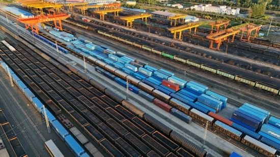這是2024年8月14日在黑龍江綏芬河鐵路口岸集裝箱換裝場拍攝的集裝箱換裝作業(yè)現(xiàn)場（無人機照片）。今年前七個月，綏芬河鐵路口岸開行中歐班列573列，運量達(dá)55246標(biāo)箱，同比分別增長23%和18%，班列數(shù)量持續(xù)保持高位運行。