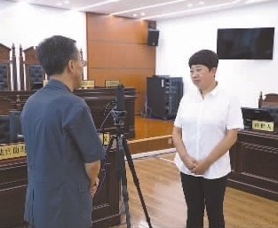 圖為全國(guó)人大代表玉明姬（右）詳細(xì)了解環(huán)境資源審判工作情況。劉思妤 攝