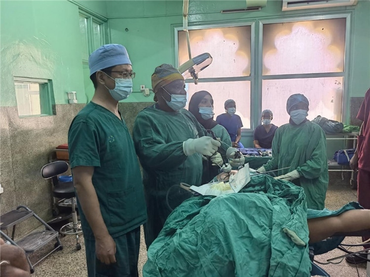 隊長蔣國慶（左一）關(guān)注當(dāng)?shù)蒯t(yī)生手術(shù)情況。中國援桑醫(yī)療隊供圖