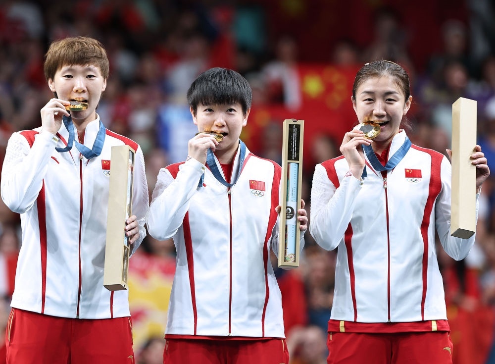 冠軍中國(guó)隊(duì)選手王曼昱、孫穎莎、陳夢(mèng)（從左至右）在巴黎奧運(yùn)會(huì)乒乓球女子團(tuán)體頒獎(jiǎng)儀式上（2024年8月10日攝）。新華社記者 王東震 攝