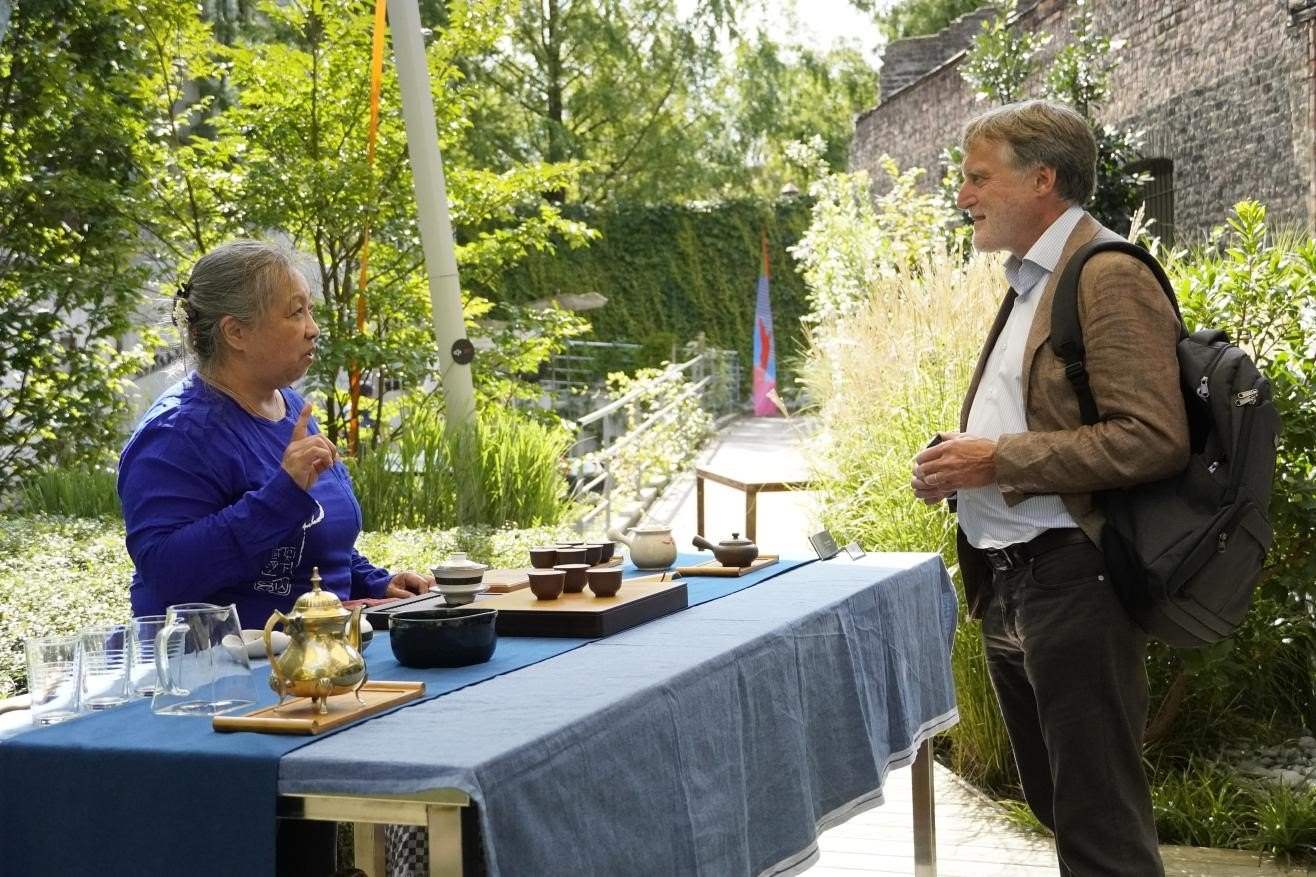 在博物館的戶外花園來賓品味中國茶藝。比利時(shí)維他命文化傳媒供圖