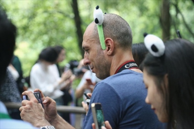 俄羅斯《俄羅斯報(bào)》視覺內(nèi)容編輯阿爾圖爾·杰魯諾夫在拍攝熊貓。（李佩藺 攝）