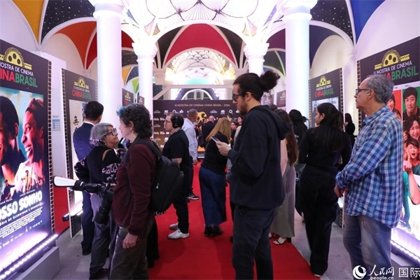 為期4天的第三屆中國(guó)－巴西電影展期間，來(lái)自中巴兩國(guó)的14部參展影片受到巴西電影愛(ài)好者和社會(huì)各界人士好評(píng)，圖為當(dāng)?shù)赜^眾在影展舉辦地巴西里約熱內(nèi)盧勞拉—阿爾維姆文化之家的迎賓廳欣賞參展電影海報(bào)。 人民網(wǎng)記者 陳一鳴攝