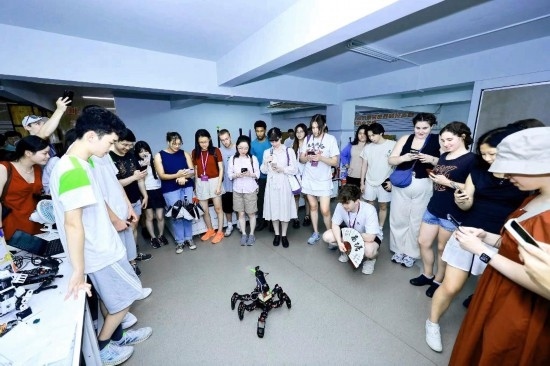 8月25日，中外青年在浙江杭州觀看機(jī)器人表演。新華社發(fā)（清華大學(xué)供圖）