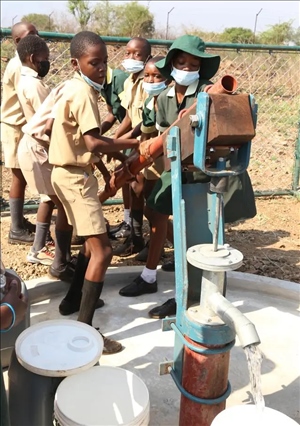 △2021年11月，在津巴布韋南馬塔貝萊蘭省省會(huì)關(guān)達(dá)的塞農(nóng)多小學(xué)，學(xué)生從中國援建水井里打水。