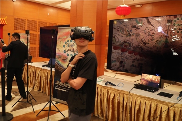 1、在本次活動(dòng)的展覽現(xiàn)場，敦煌研究院與騰訊展示了“數(shù)字藏經(jīng)洞”和“尋境敦煌”等創(chuàng)新互動(dòng)產(chǎn)品。圖為當(dāng)?shù)孛癖娡ㄟ^VR虛擬游覽洞窟。 人民網(wǎng)記者 李志偉攝