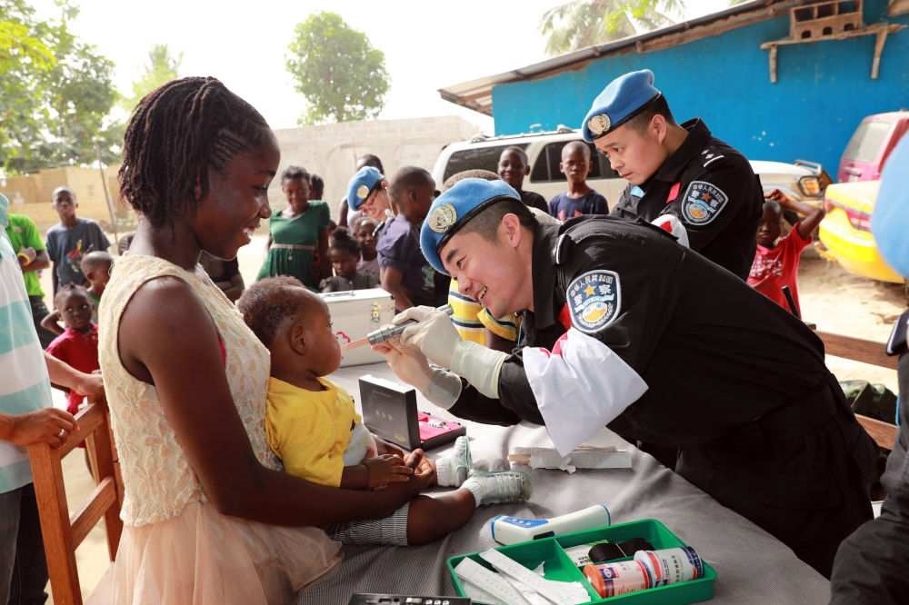 2017年12月28日，在利比里亞蒙羅維亞，中國(guó)維和警察防暴隊(duì)醫(yī)療人員為兒童做口腔檢查。