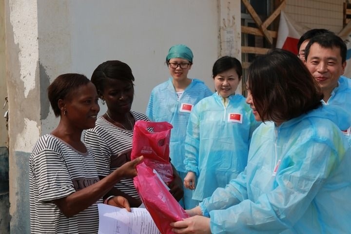 2015年4月4日，在位于塞拉利昂首都弗里敦市郊的中塞友好醫(yī)院埃博拉診療中心，中國(guó)第四批援塞醫(yī)療隊(duì)副隊(duì)長(zhǎng)邵蔚（右前）向被治愈的埃博拉出血熱患者贈(zèng)送禮物。新華社發(fā)（祖榮強(qiáng) 攝）