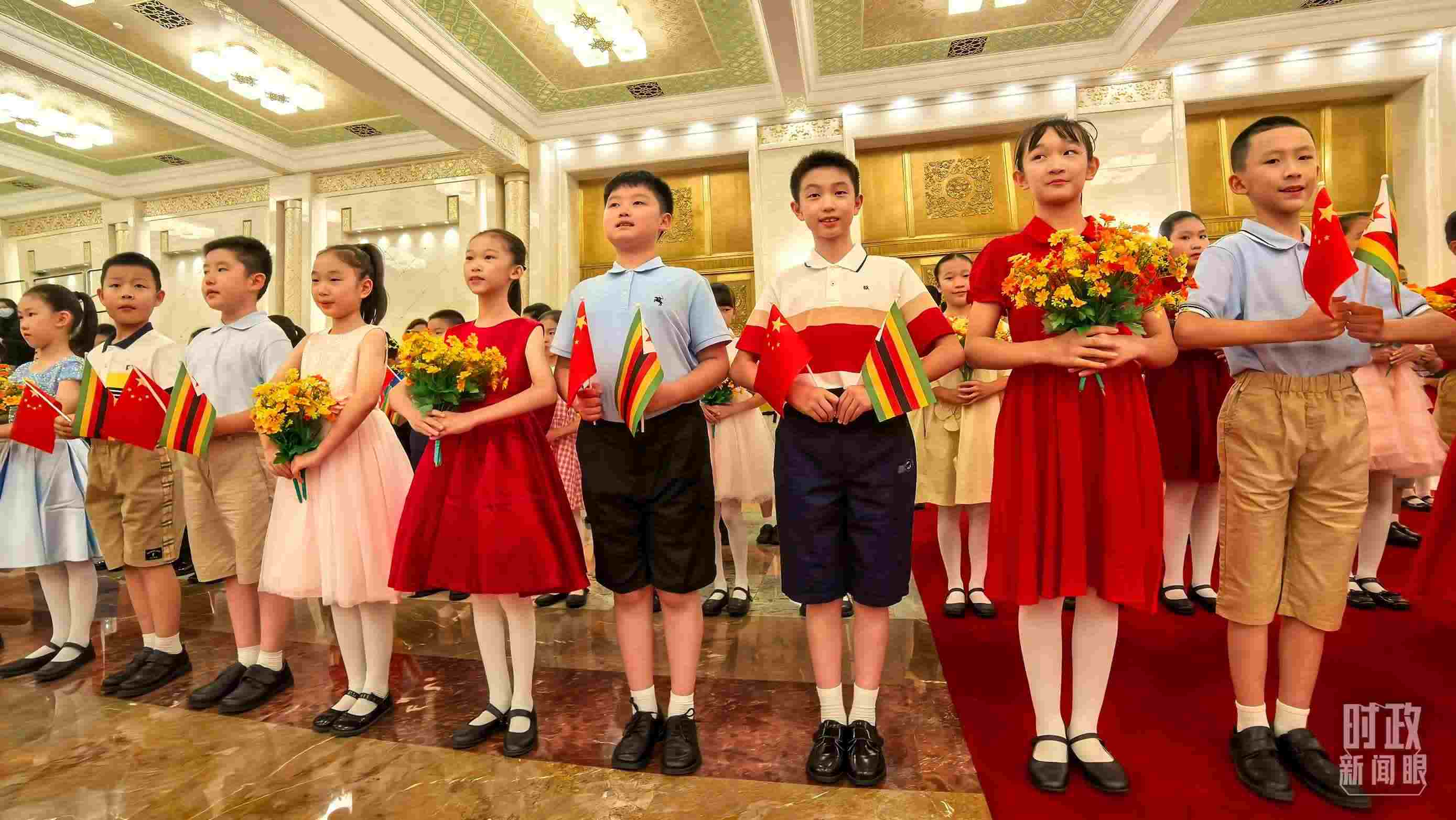 △現(xiàn)場(chǎng)歡迎津巴布韋總統(tǒng)訪華的青少年。（總臺(tái)央視記者鐘銳拍攝）