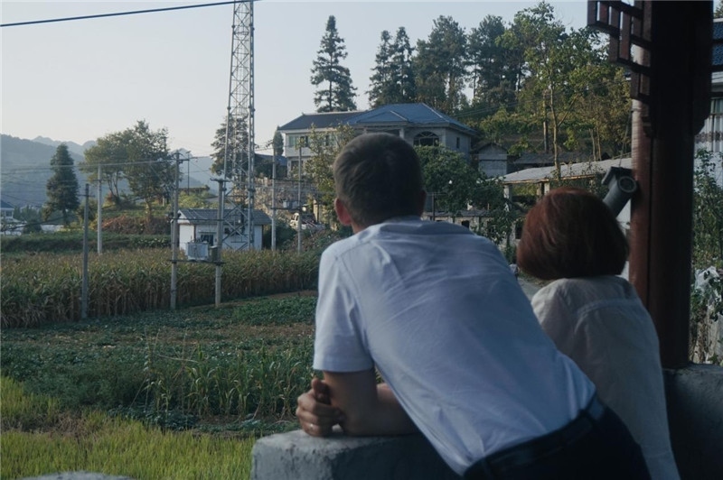 望得見山，看得見水，記得住鄉(xiāng)愁。每個人心中都有一個屬于自己的“花茂村”，在這方心田，走遍千山萬水，鄉(xiāng)音未改鬢毛衰。吉爾吉斯斯坦《比什凱克晚報》第一副總編輯妮娜·尼奇博洛娃與《中國與俄羅斯》雜志社社長奧列格·別列日內赫攝在花茂村民居屋檐下并肩佇立，眺望山水，尋覓鄉(xiāng)愁。（李光裕攝）