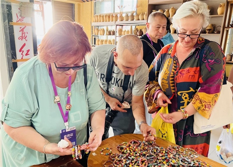 歐亞媒體考察團成員在母氏陶藝館內挑花了眼，色彩絢麗、質地均勻的陶藝手串讓他們愛不釋手?！斑@里的東西都太實惠了！”塔吉克斯坦《索格特真理報》政論部主任娜塔利婭·多羅費耶娃說?；宓奶厣a品物美價廉，讓考察團成員為家人好友買到了心儀的禮物，也為此次以四川成都為起點，路經南充、廣安至貴州遵義的考察行程畫上了圓滿句號。（張亞欣攝）