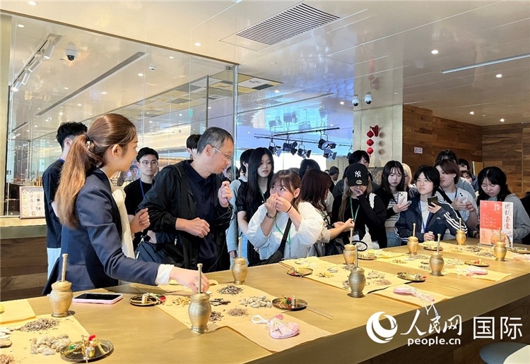 1. 日中友好協(xié)會(huì)青年代表團(tuán)一行學(xué)習(xí)中醫(yī)香囊制作工序。（人民網(wǎng)記者陳思 攝）