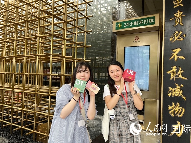 5. 代表團(tuán)團(tuán)員展示通過(guò)無(wú)人售藥機(jī)購(gòu)買的盲盒。（人民網(wǎng)記者陳思 攝）