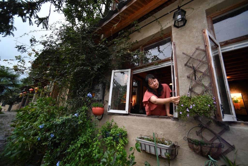 8月29日，在福建省屏南縣熙嶺鄉(xiāng)，龍?zhí)洞濉靶麓迕瘛泵泛暝诖蚶碜约航?jīng)營的民宿外墻裝飾花盆。新華社記者姜克紅 攝